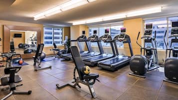 A gym with treadmills, weight machines, and exercise balls.
