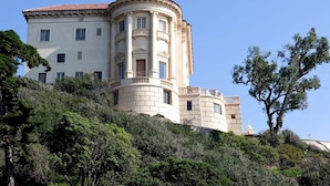 Un edificio grande de varios pisos con estilo arquitectónico clásico, que presenta una fachada curva y numerosas ventanas.