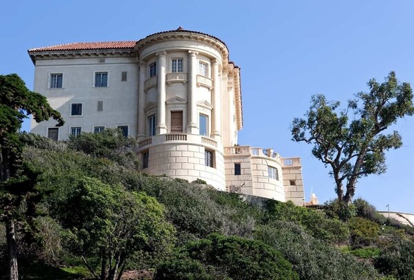 Un grand immeuble à étages, de style architectural classique, caractérisé par une façade incurvée et de nombreuses fenêtres.