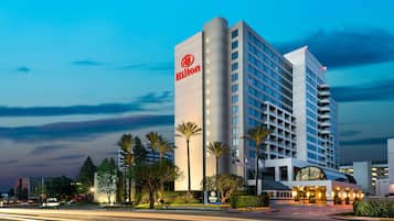 Ett modernt hotell med en tydlig Hilton-logotyp, flera våningar och en väl upplyst entré.