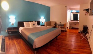 A hotel room with a large bed, bedside tables, a desk, and a chair. - Motel 6 Nashville, TN - Airport (Nashville)