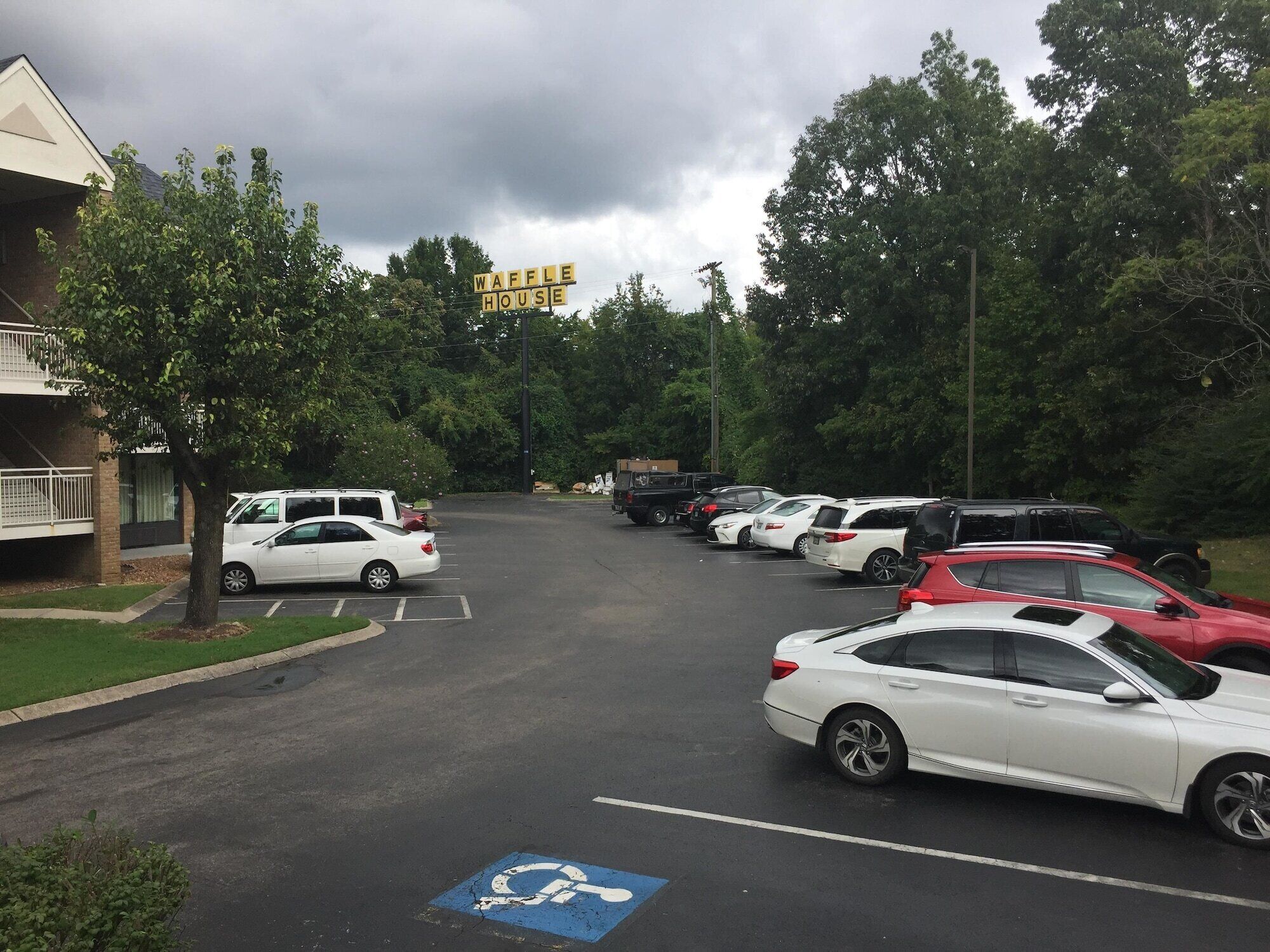 A parking lot with multiple cars and a building labeled "WAFFLE HOUSE" in the background.