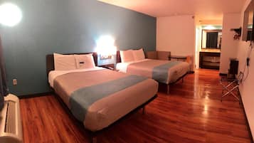 Een hotelkamer met twee bedden, een tafeltje en een stoel.