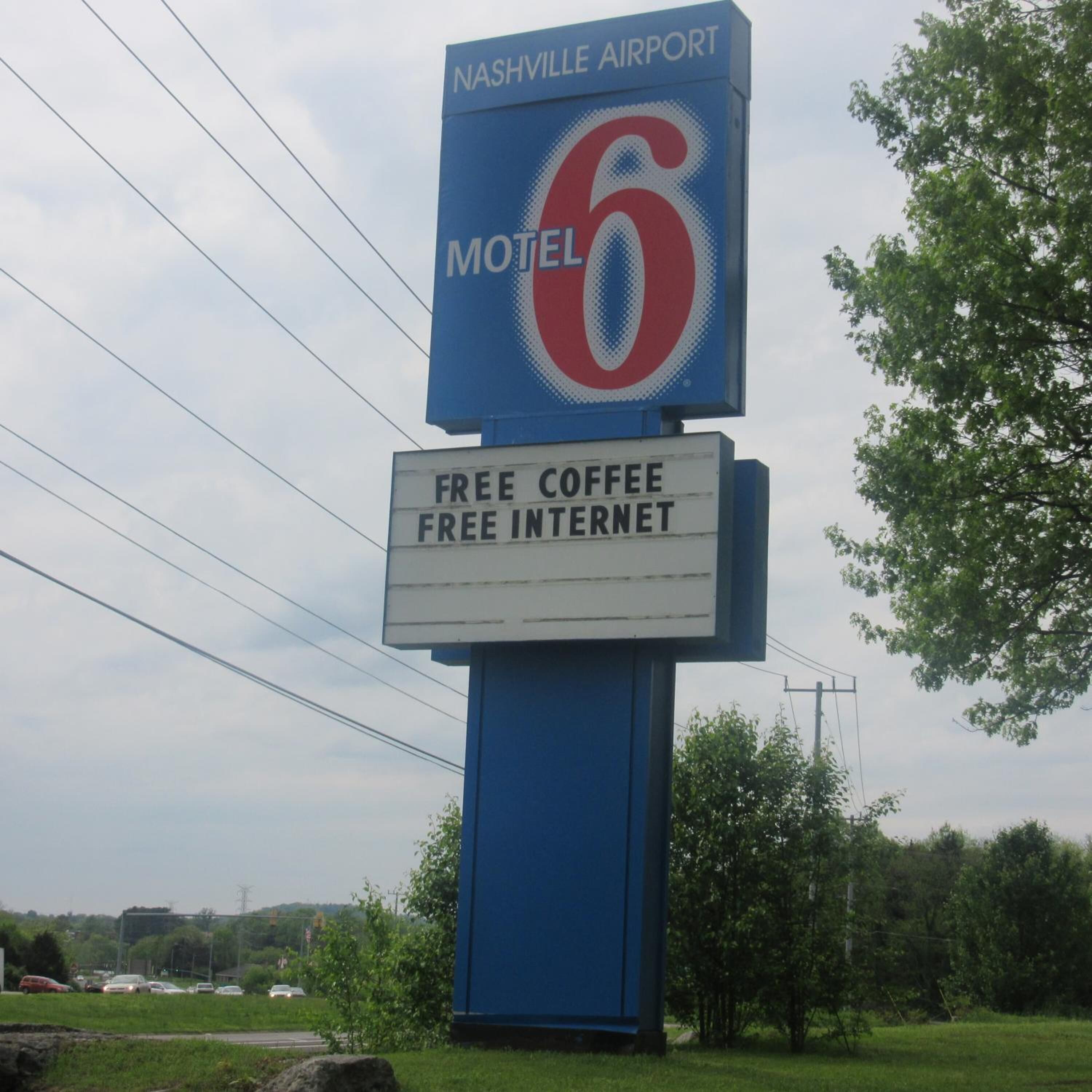 Une enseigne de motel indiquant « Aéroport de Nashville » et « Motel 6 », et une autre enseigne en dessous indiquant « Café gratuit, accès Internet gratuit ».