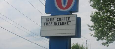 A motel sign with "Nashville Airport" and "Motel 6" on it, and a sign below stating "Free Coffee Free Internet".