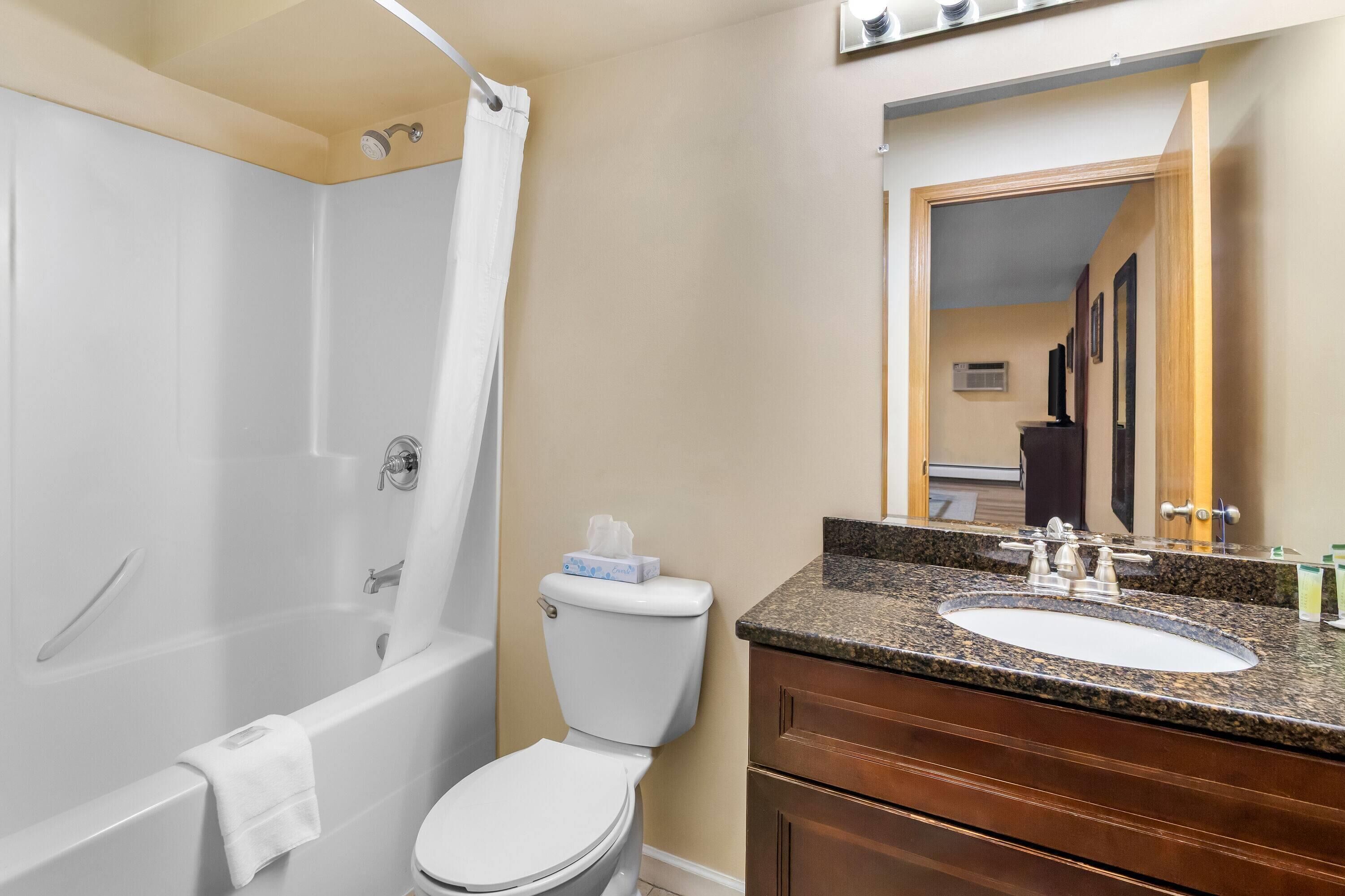 Un baño con bañera, inodoro y lavamanos.
