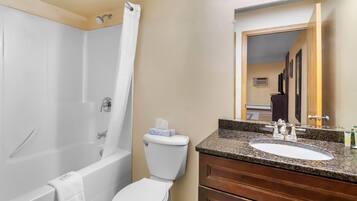 A bathroom with a bathtub, toilet, and sink.