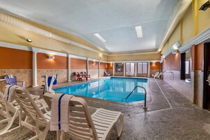 Una piscina techada, sillones reclinables de piscina