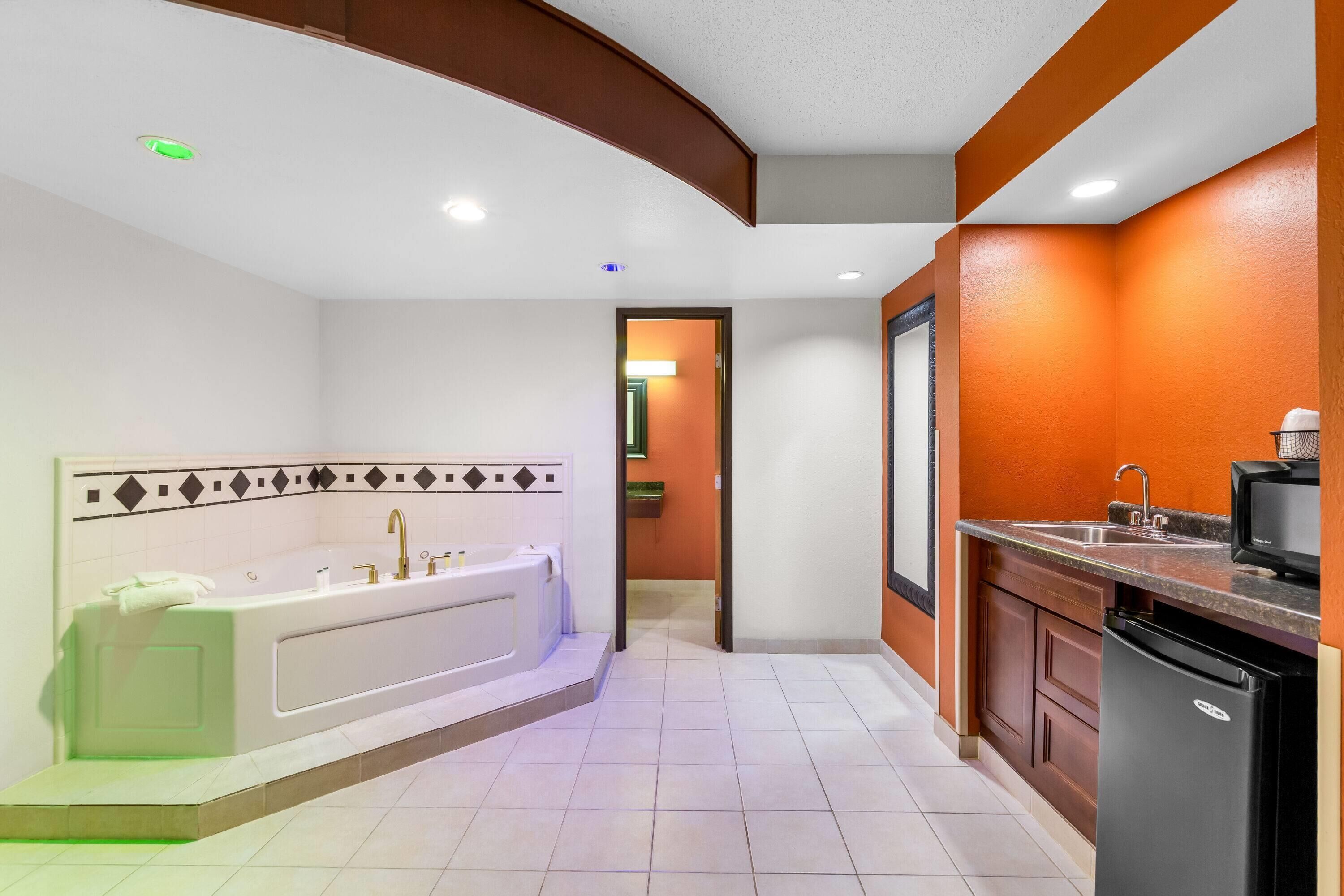 Une salle de bain moderne équipée d’une baignoire, d’un lavabo et d’un réfrigérateur.