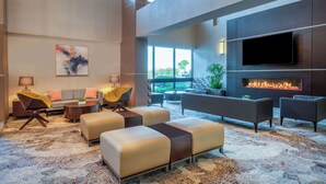 Un salon moderne doté d’un téléviseur à écran plat, d’une cheminée et de sièges confortables.