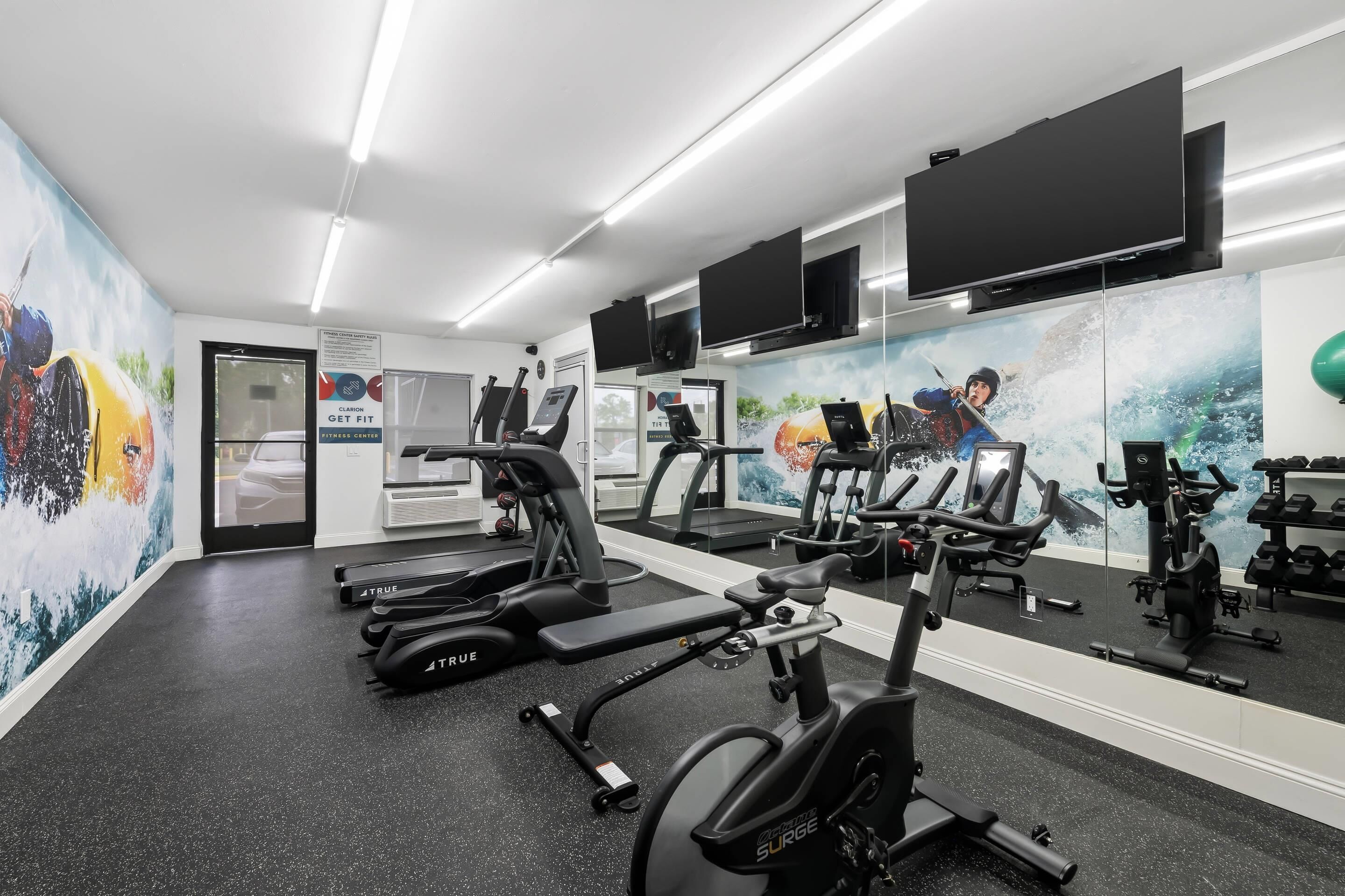 Ein Fitnessstudio mit Laufbändern, Ergometer und Gewichten.