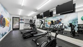 Ein Fitnessstudio mit Laufbändern, Ergometer und Gewichten.