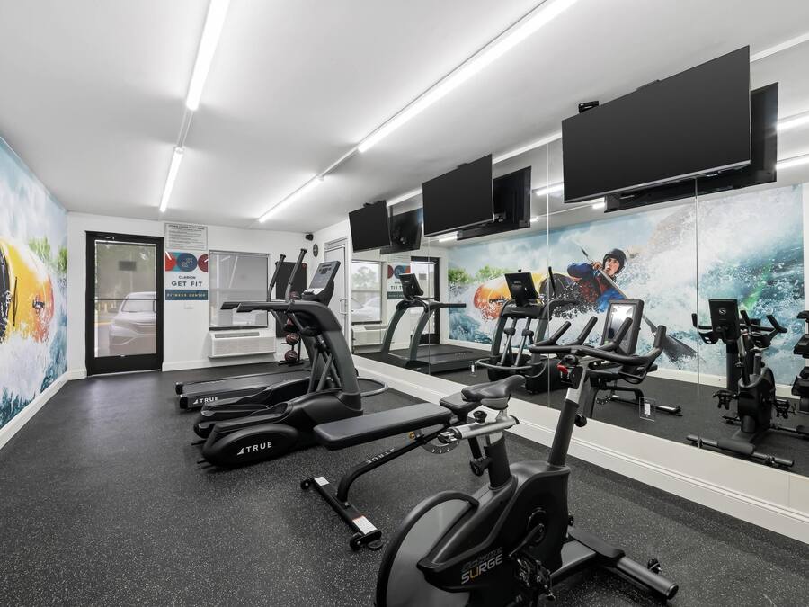 Ein Fitnessstudio mit Laufbändern, Ergometer und Gewichten.