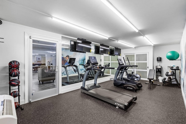 A home gym with treadmills, stationary bikes, and exercise balls.