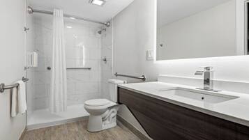 A modern bathroom with a shower, toilet, and vanity.
