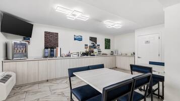 A modern cafe with a counter, coffee machines, and seating.