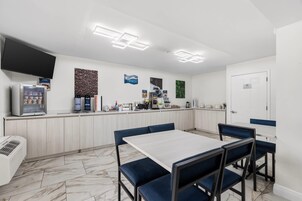 Un café moderno con mostrador, máquinas de café y mesas.