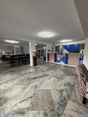 Experience the hotel's inviting lobby, featuring a reception desk, comfortable seating area, and beautiful artwork.