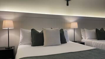 Camera d'albergo con un letto grande, due comodini, un lampadario a parete e un elemento decorativo a parete.