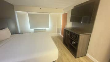 Une chambre d’hôtel équipée d’un lit, d’une télévision, d’un four à micro-ondes et d’une armoire.