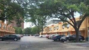 A row of parked cars along a tree-lined street with multi-story buildings in the background. - Chicago Lake Shore Hotel (Chicago)