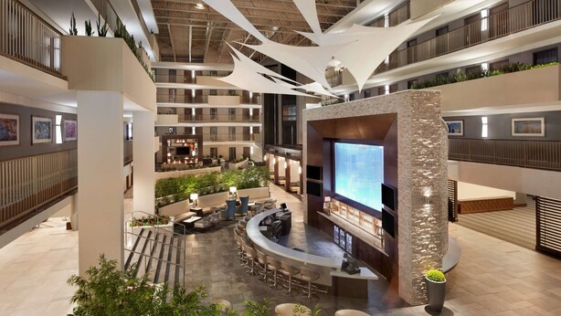 A spacious indoor area with multiple levels, a central bar area, and seating arrangements.