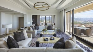 A spacious living room with a large sofa, a coffee table, and a view of the city through large windows. - Beverly Wilshire, Beverly Hills, A Four Seasons Hotel (Beverly Hills)