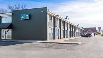 En moderne bygning med skilt, der viser 'Quality Suburban Studios'.