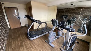 A gym with treadmills, elliptical machines, and a mirror wall. - Reliance Inn (Wausau)