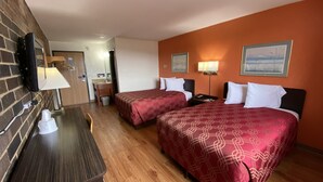 A hotel room with two beds, a desk, a TV, and a bathroom visible through an open door. - Reliance Inn (Wausau)