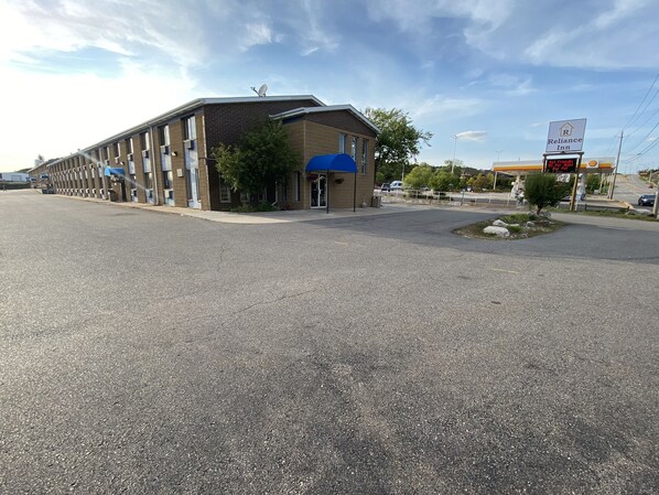 A building with a flat roof, a satellite dish, and a sign for Reliance Inn.