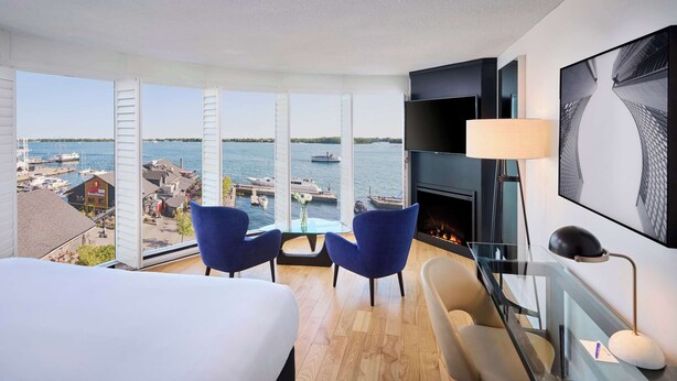 Hotelkamer met een groot raam en uitzicht op een jachthaven en boten.