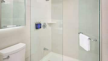Een moderne badkamer met een douche met glazen wand, een toilet en een spiegel.