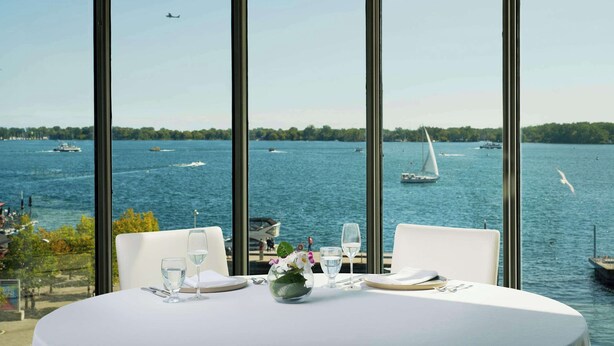 A table set for two with a view of a lake and boats. - Radisson Blu Toronto Downtown (Toronto)