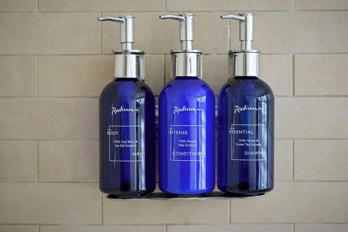 Tre flasker Radisson BLU showergel, balsam og shampoo.
