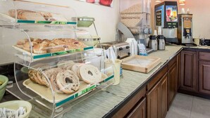 A breakfast buffet with various pastries, a coffee machine, and a juice dispenser. - Quality Inn Dahlonega Near University (Dahlonega)
