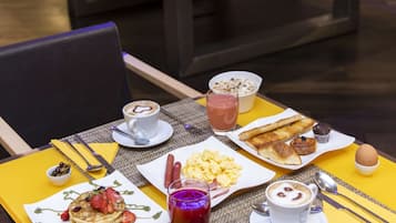 En morgenmadsbuffet med forskellige retter, blandt andet pandekager, æg og bagværk.