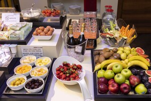 Un buffet con un'ampia scelta di cibi, tra cui frutta, verdura e bevande.