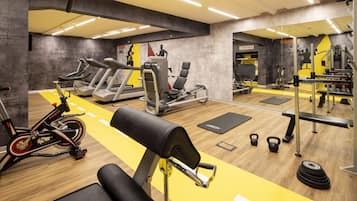 A gym with treadmills, a stationary bike, weight machines, and free weights.