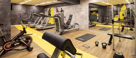 A gym with treadmills, a stationary bike, weight machines, and free weights.