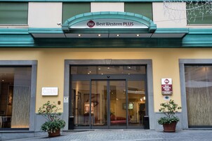 Esterno dell'hotel Best Western PLUS con ingresso in vetro, piante in vaso e insegna che indica che si tratta di un hotel cittadino.