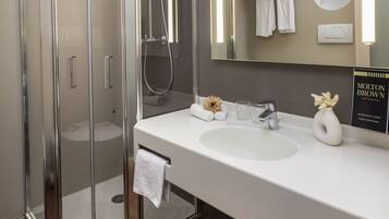 Un bagno moderno con doccia vetrata, lavandino bianco e uno specchio grande.