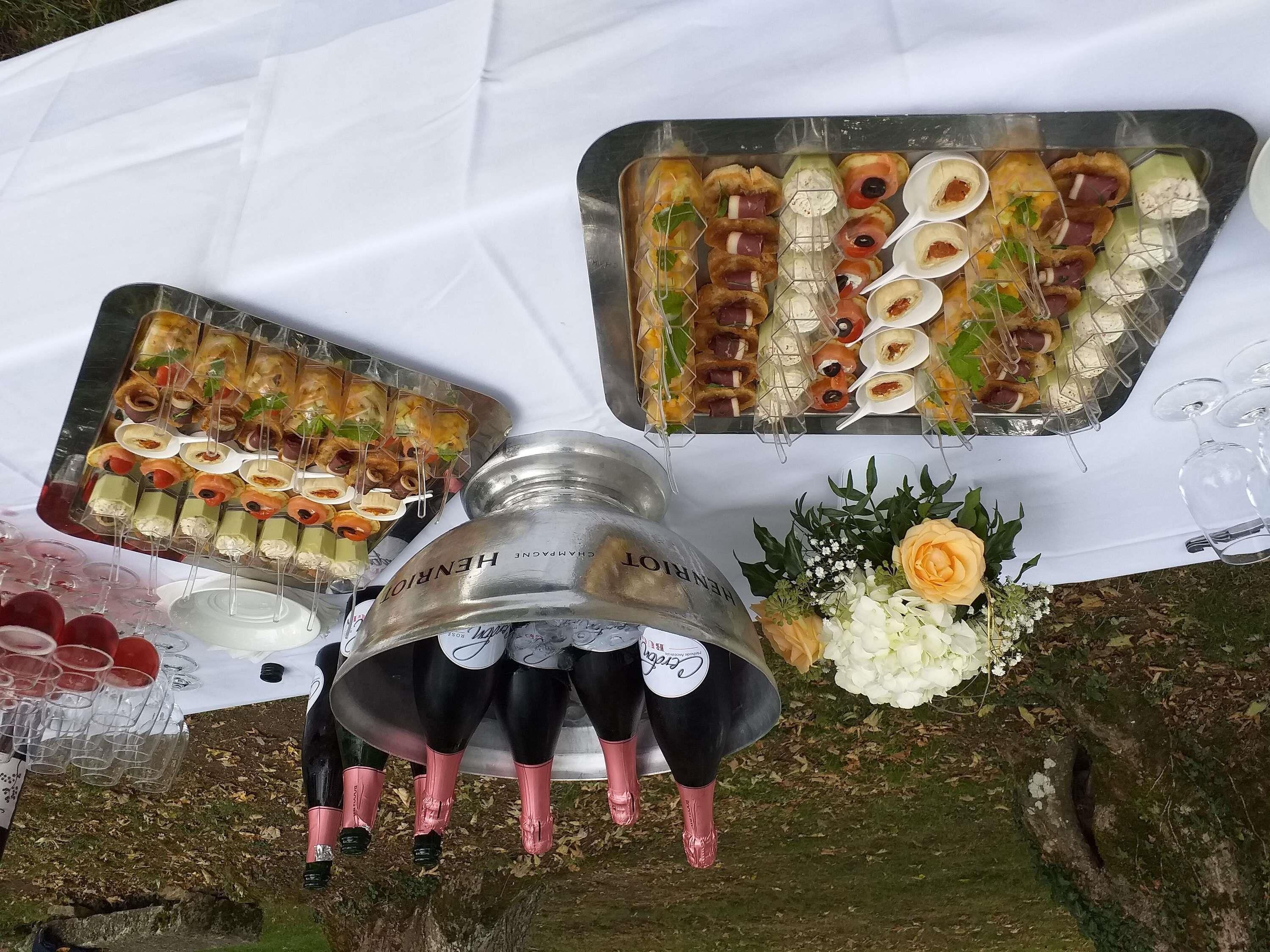 Uma mesa com diversos alimentos e garrafas de champanhe.