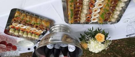 Uma mesa com diversos alimentos e garrafas de champanhe.