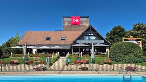 Hotel con piscina, mobiliario exterior y un cartel que dice 'lafarmeauxvins'.