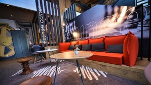 Un área de estar moderna con un sofá rojo, una mesa redonda y una mesa de centro de madera.