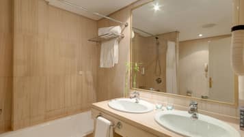 A modern bathroom with two sinks, a large mirror, and a shower.
