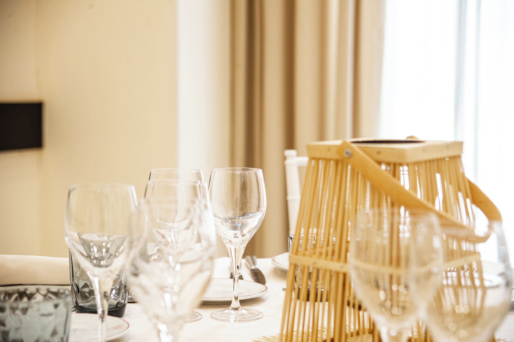 A table set with wine glasses and a wicker basket.