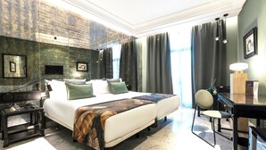 A hotel room with a large bed, a desk, a chair, and a desk lamp. - AZZ Mérida Medea (Merida)