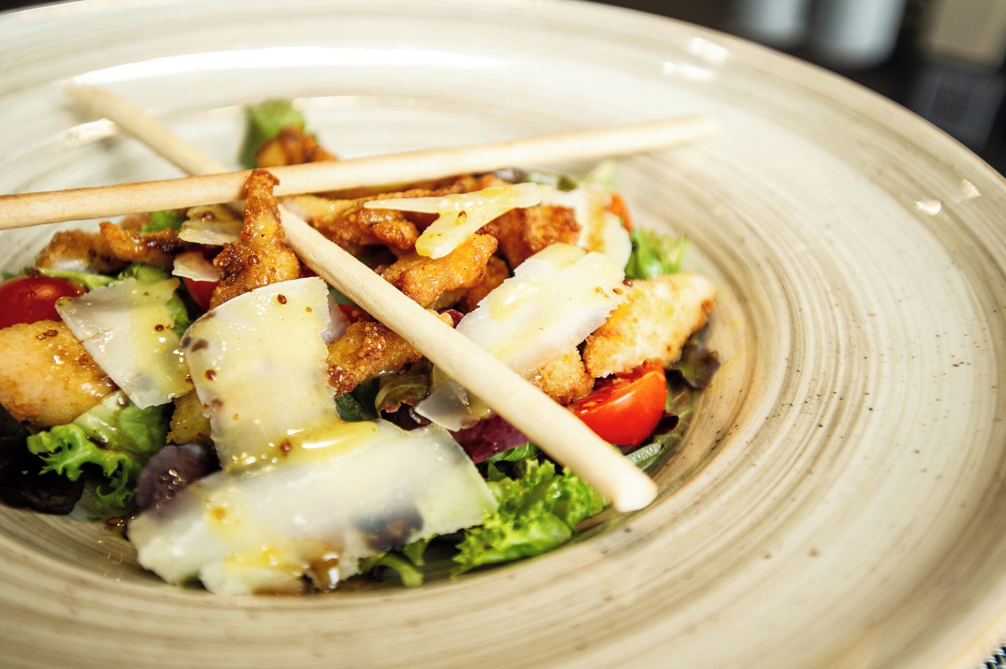 A plate of food with a salad, croutons, and a creamy dressing.